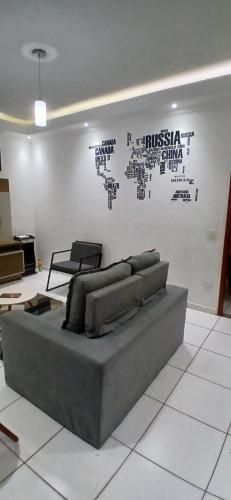 a couch sitting in a living room with a wall at Casa Aconchegante in Espirito Santo Do Pinhal
