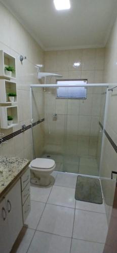 a bathroom with a shower and a toilet and a sink at Casa Aconchegante in Espirito Santo Do Pinhal