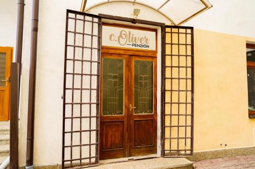 a building with a wooden door with a sign on it at Penzión Oliver Humenné in Humenné