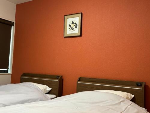 a bedroom with two beds and a picture on the wall at Higashiyama Chitaru in Kanazawa in Kanazawa
