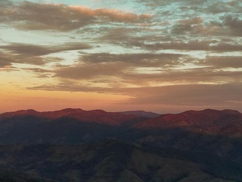 a view of a mountain range with a sunset at Nosara Hideaway 3 - BREAKFAST INCLUDED & Mountain View Cabins in Nosara