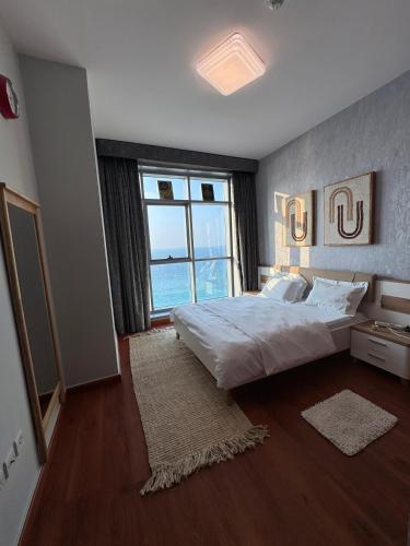 a bedroom with a large bed and a large window at sand and beach haven at Ajman Corniche! in Dubai