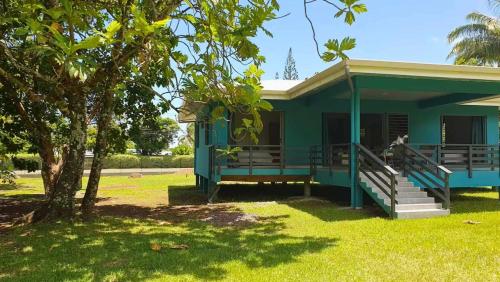 a green house with a tree in the yard at TAHITI ITI - Fare Vaiavaro in Teahupoo