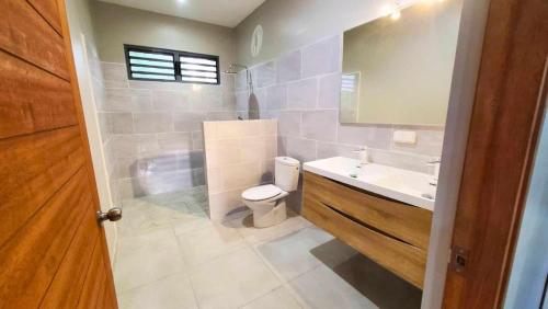 a bathroom with a toilet and a sink and a tub at TAHITI ITI - Fare Vaiavaro in Teahupoo