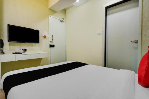 a bedroom with a white bed and a television at Super Collection O Snowfox in Kolkata