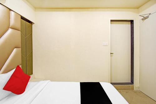 a bedroom with a white bed with a red pillow at Super Collection O Snowfox in Kolkata
