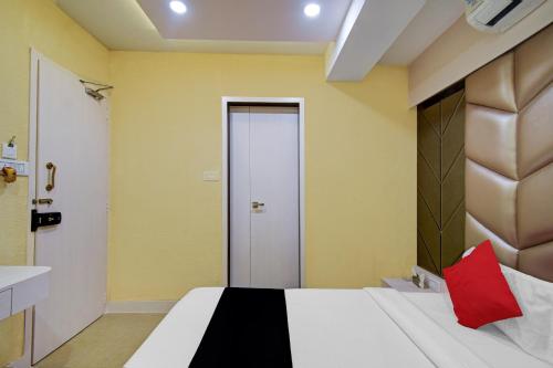 a bedroom with a bed with a red pillow on it at Super Collection O Snowfox in Kolkata
