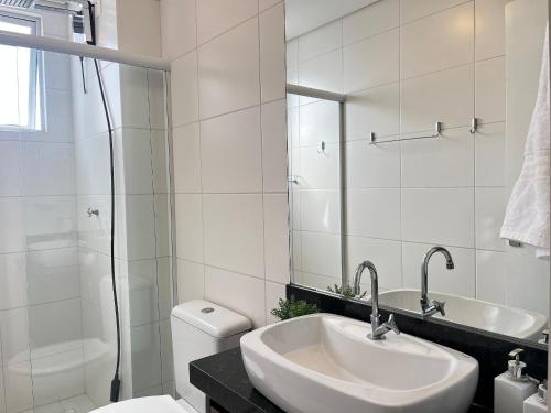 une salle de bain avec un lavabo, des toilettes et une douche dans l'établissement Residencial Porto Piçarras - Itacolomi, à Balneário Piçarras