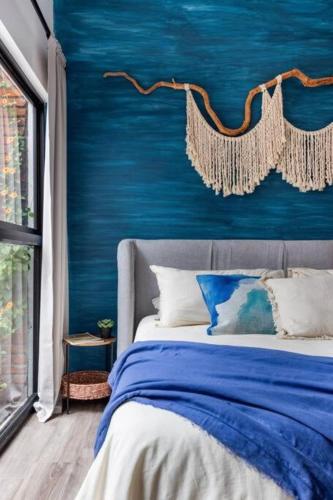 a blue bedroom with a bed and a blue wall at 2 - Apartamento Privado Cama King Size, Terraza Privada Roma Sur in Mexico City