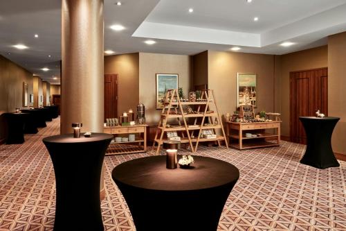 a salon with tables and shelves in a room at Sheraton Grand Krakow in Kraków