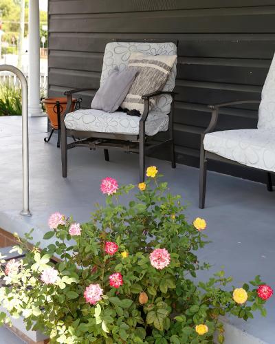 a couple of chairs and flowers on a porch at Ellson House - The Heart of the Hunter in Cessnock