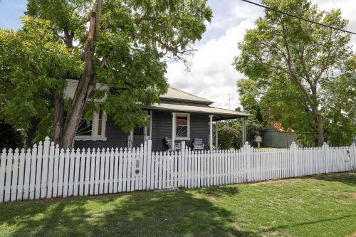 a white picket fence in front of a blue house at Ellson House - The Heart of the Hunter in Cessnock