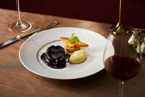 a white plate with food on a wooden table at The St. Regis Osaka in Osaka