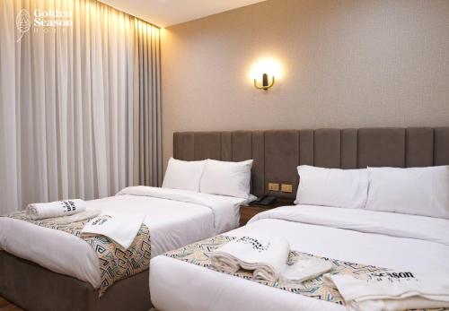 two beds in a hotel room with white sheets at Golden Season Hotel in Cairo