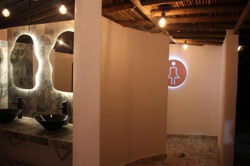 a bathroom with a sign on the wall at Río Celeste Poshtel Tayrona - Zaino in Calabazo