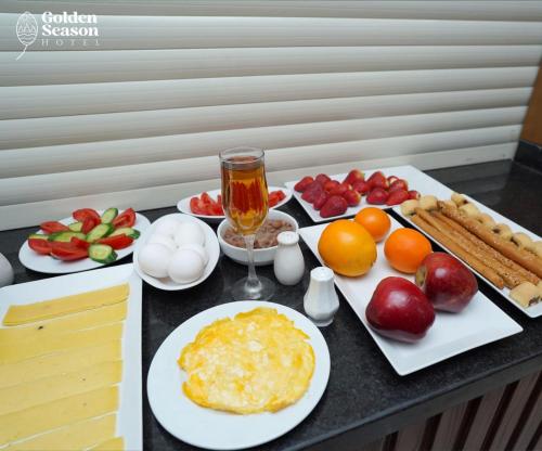 a table topped with plates of food and fruit at Golden Season Hotel in Cairo