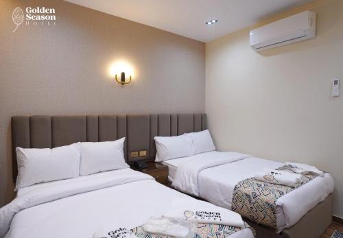 a hotel room with two beds with white sheets at Golden Season Hotel in Cairo