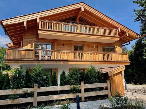 a large wooden house with a large balcony at Holiday apartment Bergliebe on Lake Tegernsee in Rottach-Egern