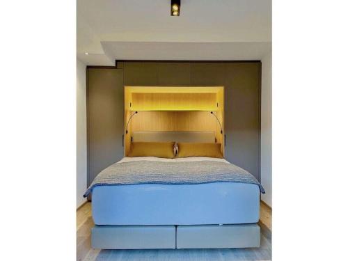a bed with a yellow headboard in a bedroom at Holiday apartment Bergliebe on Lake Tegernsee in Rottach-Egern