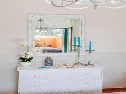 a dresser with a mirror and two candles on it at Apartment near Ostia Antica with Jacuzzi in Torvaianica