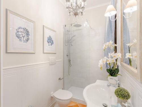 a white bathroom with a toilet and a sink at Apartment near Ostia Antica with Jacuzzi in Torvaianica