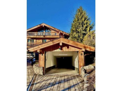 a large wooden house with a large garage at Holiday apartment Bergliebe on Lake Tegernsee in Rottach-Egern