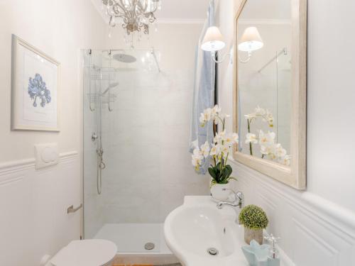 a white bathroom with a sink and a shower at Apartment near Ostia Antica with Jacuzzi in Torvaianica