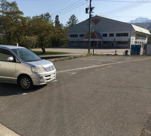 a car parked in a parking lot in front of a building at Lodge Shosen in Otari