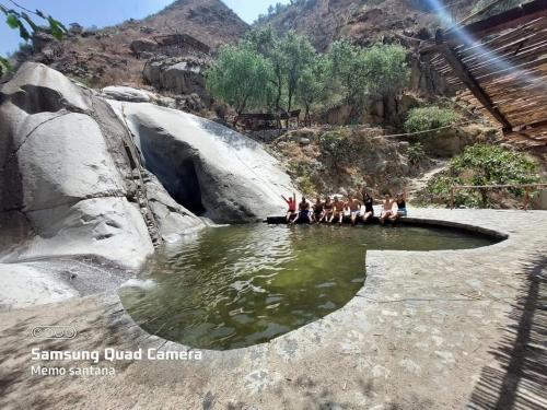 a group of people standing around a pool of water at Restobar & Hotel Campestre Aisha in Cocachacra