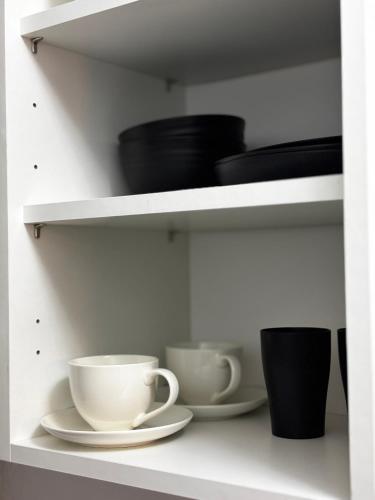 a white shelf with bowls and cups on it at The Ivy Cinema Suite in Luton