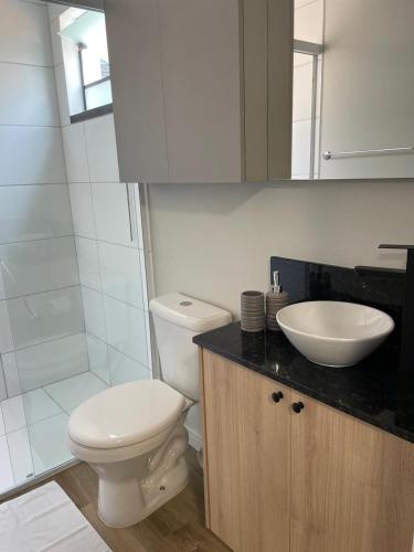 a bathroom with a white toilet and a sink at Konell Apartment 205 in Pomerode
