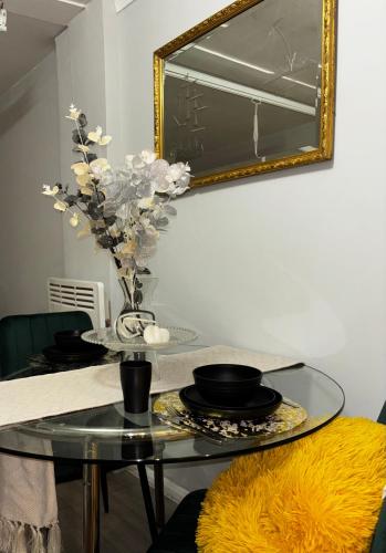 a glass table with a vase of flowers on it at The Ivy Cinema Suite in Luton