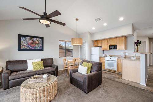 a living room with two couches and a kitchen at Still Waters Resort in Branson