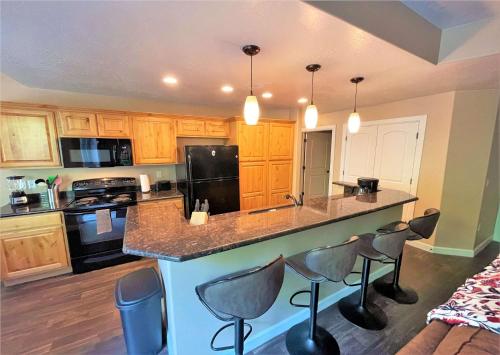 una cocina con isla con taburetes de bar en 3-Bedroom Luxury Condo in the Heart of the City, en Salt Lake City