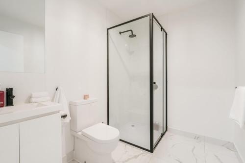a bathroom with a toilet and a glass shower at Tree Top Treasure Itas in Kings Meadows