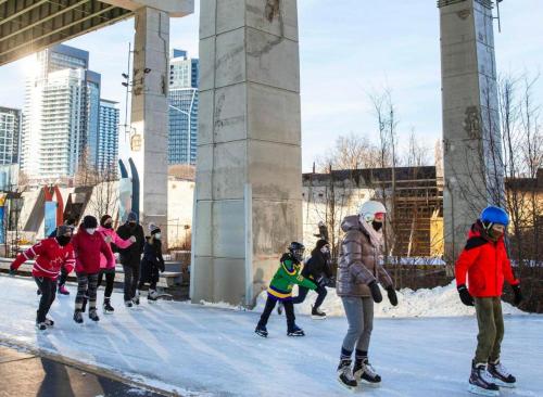 a group of people playing in the snow under a bridge at CN Tower Luxe Suites - Prime Downtown Location in Toronto