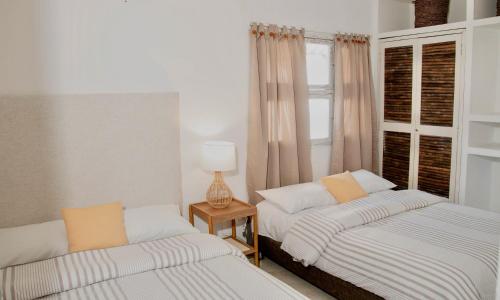 deux lits dans une chambre avec une fenêtre dans l'établissement Apartamento Benitez 301 by Zakher, à Carthagène des Indes