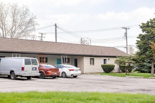two cars parked in a parking lot in front of a house at Stay in Browntown for 4: Cozy Room with MiniFridge in Woodhaven