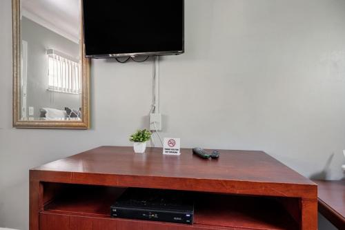 una mesa de madera con TV encima. en Warm Private Room in Detroit for Up to 4 w WiFi, en Woodhaven