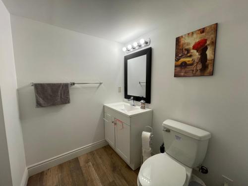 a bathroom with a toilet and a sink and a mirror at Quiet and Private Bachelor Unit in Halifax