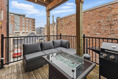 a patio with a couch and a table on a balcony at downtown Indy with Fire Pit and Free Parking in Indianapolis
