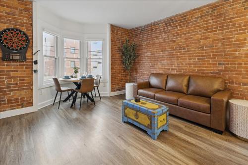 a living room with a couch and a brick wall at downtown Indy with Fire Pit and Free Parking in Indianapolis