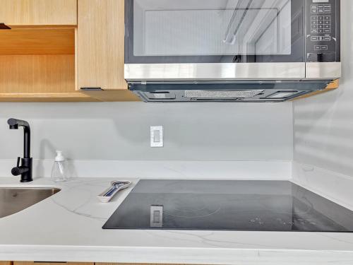 una cocina con fregadero y microondas en Beachside 1BR Apt - Walk to Hollywood Dania Beach, en Dania Beach
