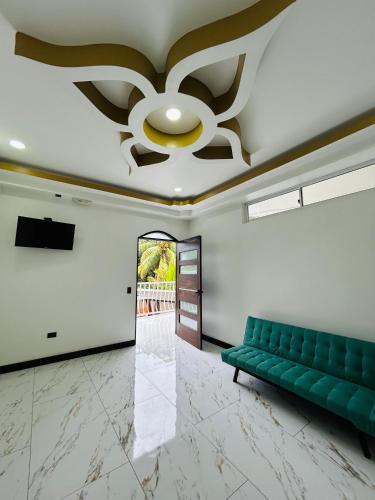 a living room with a green couch and a ceiling at Villa del Mar Hotel Boutique in Cahuita