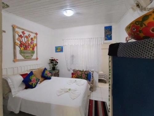 a bedroom with a white bed and a couch at Recanto da Vera in Ilhabela