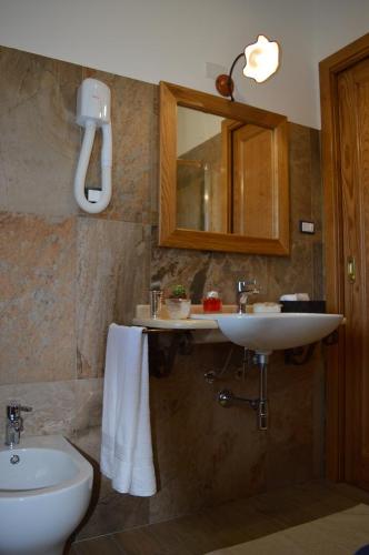 カルデードゥにあるAgriturismo S'Orgiolaのバスルーム(洗面台、トイレ、鏡付)