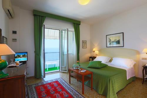 シルヴィ・マリーナにあるHotel Mion Charme & Relaxのベッドとバルコニー付きのホテルルーム