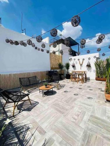 a patio with chairs and tables and a blue sky at 0 - Suite de Lujo Confort Cama Queen Size Roma Sur in Mexico City