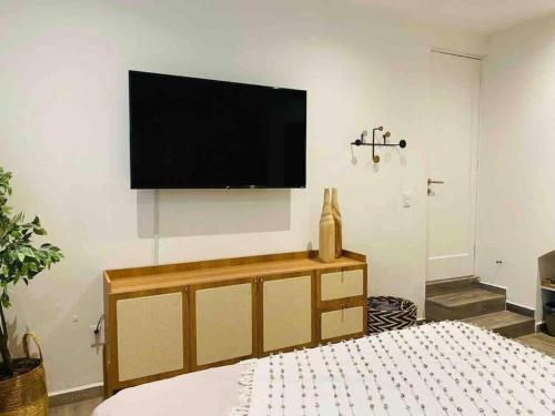 a bedroom with a flat screen tv on the wall at 0 - Suite de Lujo Confort Cama Queen Size Roma Sur in Mexico City