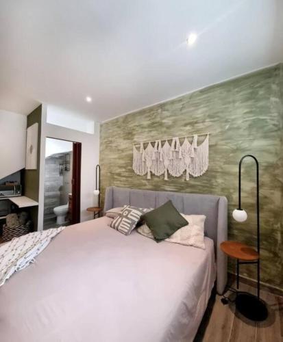 a bedroom with a white bed and a green wall at 0 - Suite de Lujo Confort Cama Queen Size Roma Sur in Mexico City